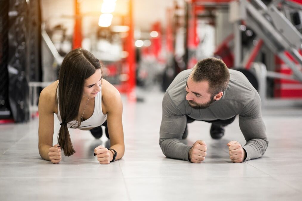 يقوم رجل وامرأة بتمرين بلانك ، وهو مصمم لجميع مجموعات العضلات